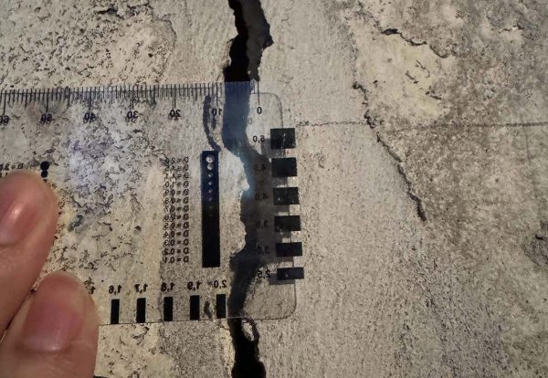 Measured crack documentation for forensic engineering Measured concrete crack with scale for forensic documentation