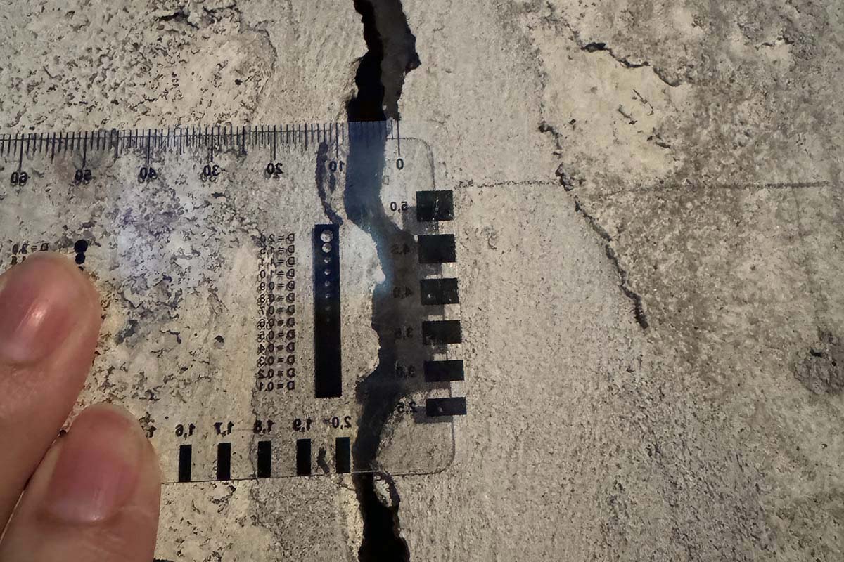 Measured concrete crack with scale for forensic documentation