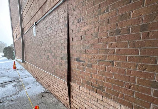 Bulging brick veneer panel with visible outward displacement Bulging brick veneer wall between vertical joints showing outward displacement