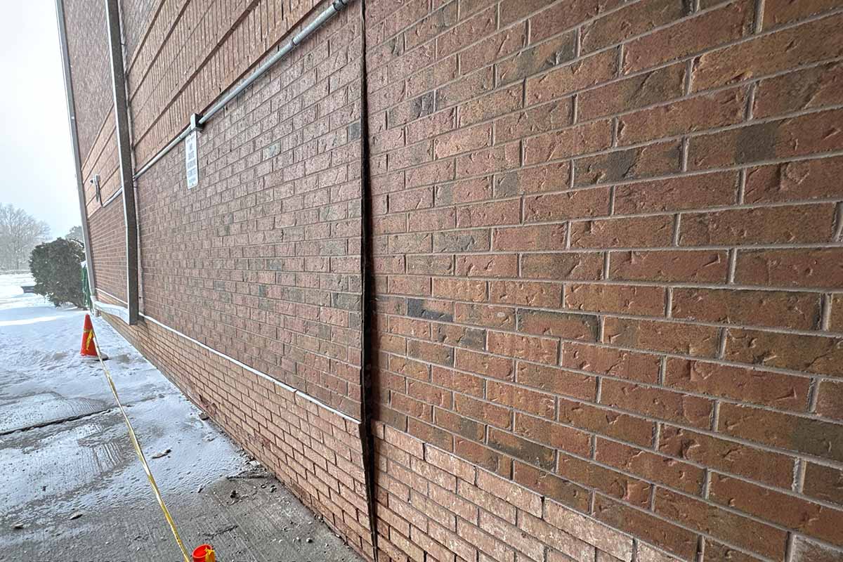 Bulging brick veneer wall between vertical joints showing outward displacement