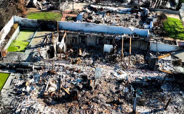Post-Fire Residential Site Assessment Aerial view of a residential structure fire site with exposed concrete foundation walls and debris.